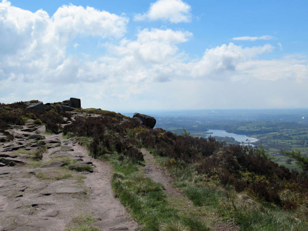 Looking out over Tittesworth Reservoir from the top of the Roaches under the cover of a fluffy white cloud sky