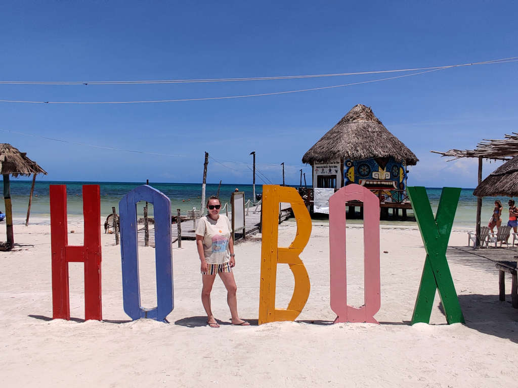 Zoe stood in the Holbox sign forming the letter L in the word. The letters are large and brightly coloured